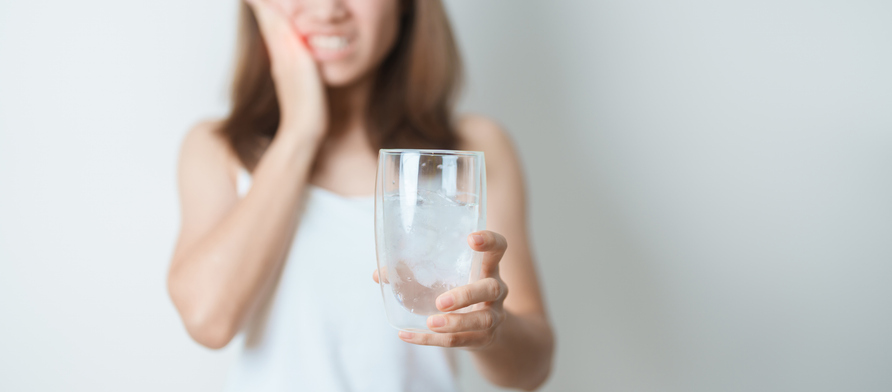 Teeth Sensitive to Cold concept. woman hold Ice Water glass and having toothache and pain after eat. Tooth Decay or Gum Disease, Grinding Teeth and Stress, Exposed Nerve Roots, Crack and Receding Gums