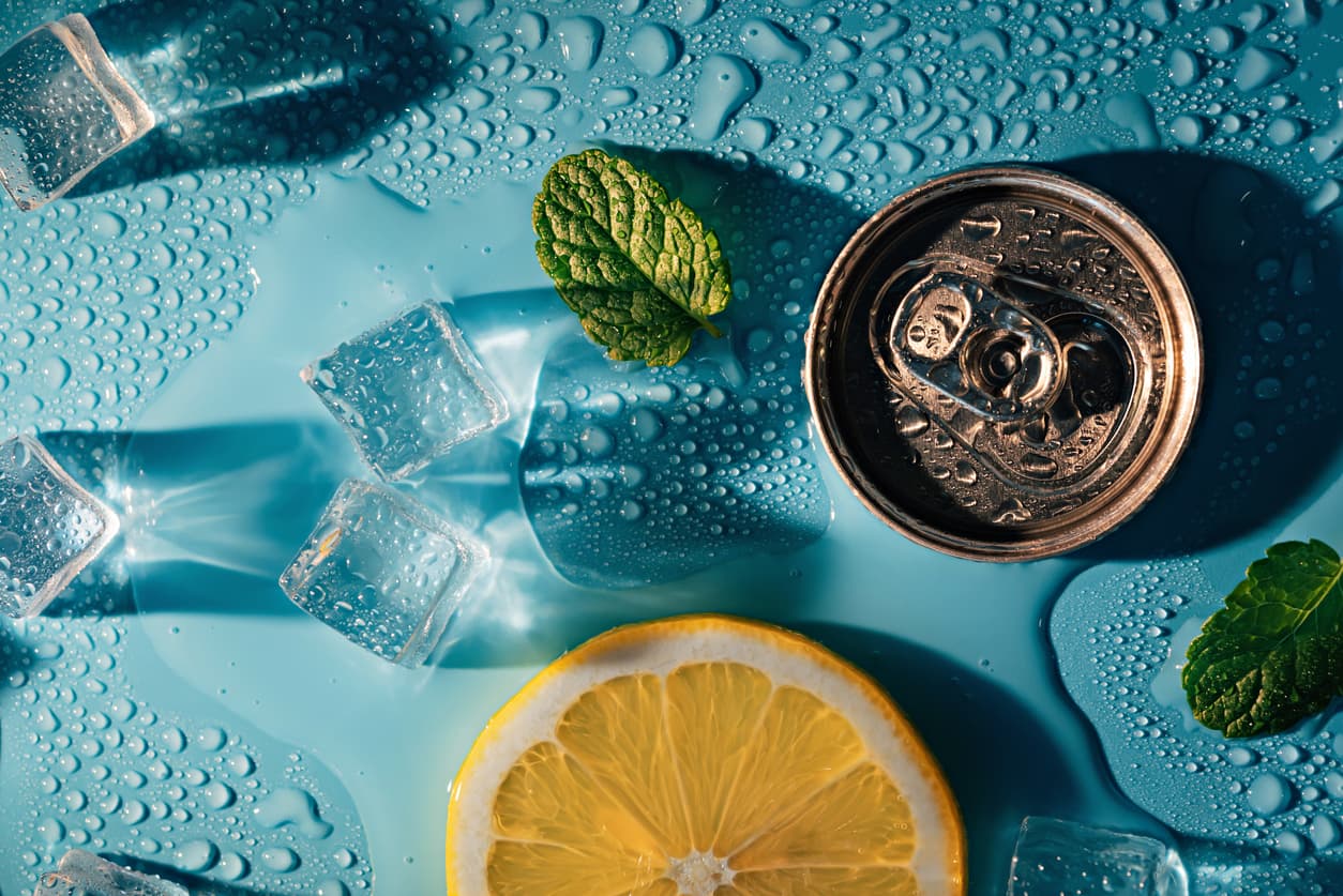 blue background with ice mint lemon and a can of soda